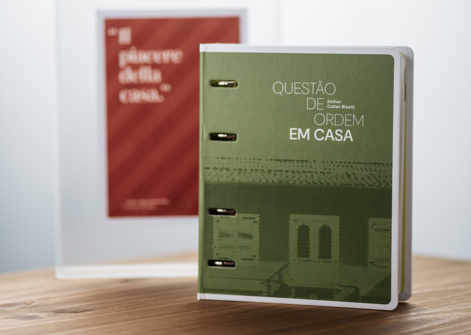 Livro Questão de Ordem em Casa com card inspirativo ao fundo.